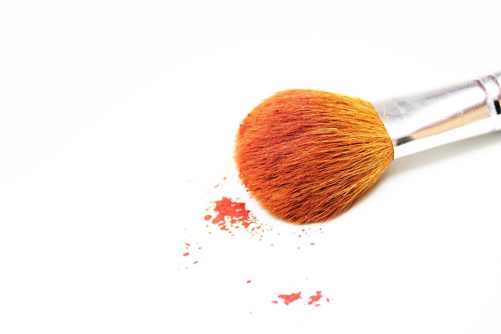 Pennelli da trucco disposti su fondo bianco